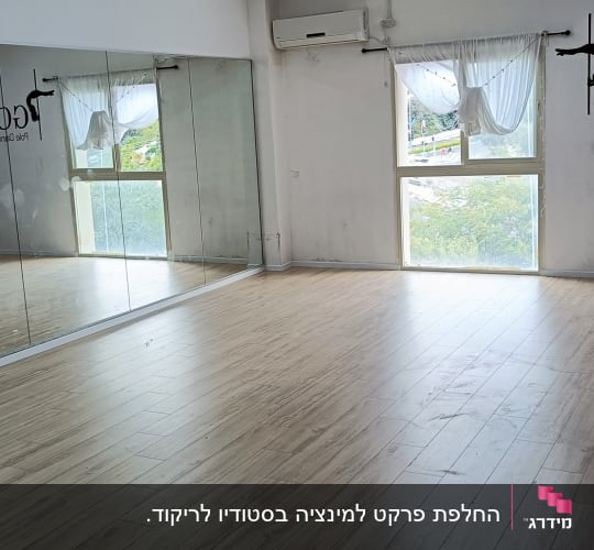 רצפת פרקט עץ בחדר סטודיו עם מראות